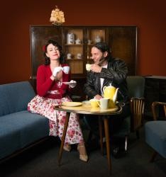 Frau und Mann in Klamotten der 50er Jahre beim Kaffeetrinken