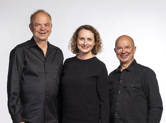 3 Personen in schwarz gekleidet, lachend