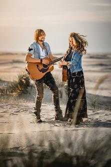 2 Personen mit Gitarre im Sand